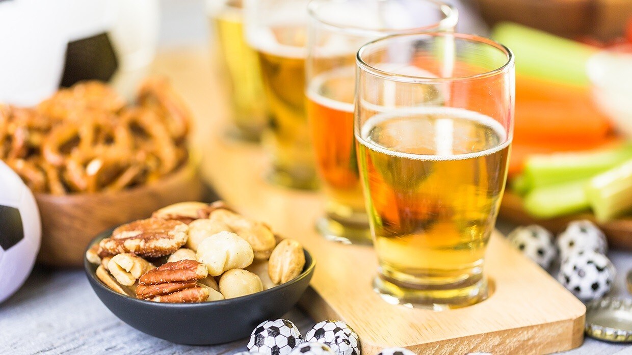 Copas con cerveza acompañadas de nueces y pretzels. Copas con cerveza acompañadas de nueces y pretzels.