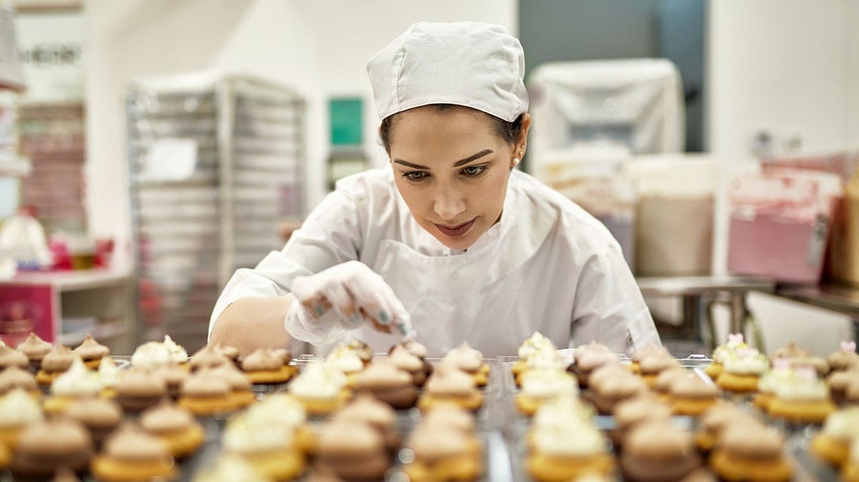 chef dando últimos detalles a pastelillos para servicio de catering