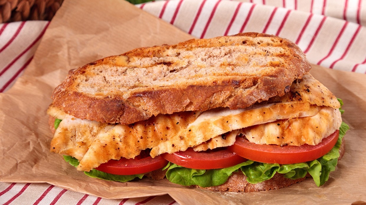 Sandwich de pollo con lechuga y tomate para picnic.