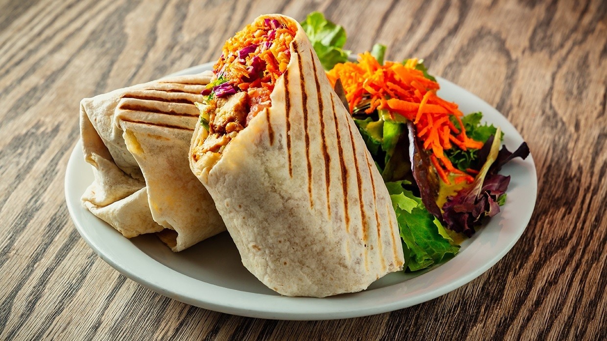 Wrap de pollo servido con ensalada, perfecto para combinar con aderezo para ensalada caesar.