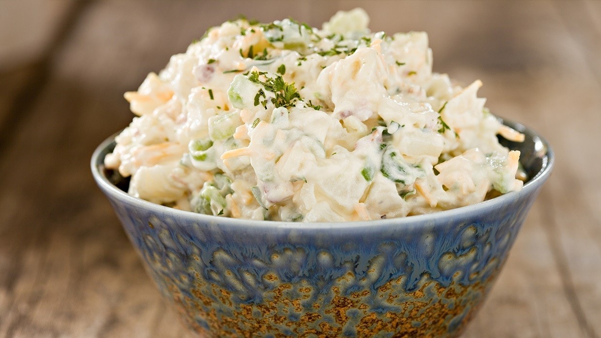 Plato de ensalada de papa con mayonesa vegana.